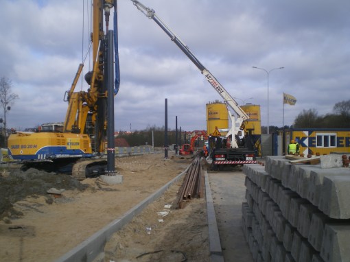 Budowa linii tramwajowej przy ulicy Płoskiego (17 kwietnia 2015) - ustawianie słupów trakcyjnych