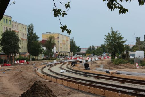 Budowa linii tramwajowej w ulicy Wilczyńskiego, między ulicą Wachowskiego a przyszłym przystankiem końcowym Pieczewo (1 lipca 2022) - pierwsze zespawane już szyny w śladzie torowiska czekają na umocowanie