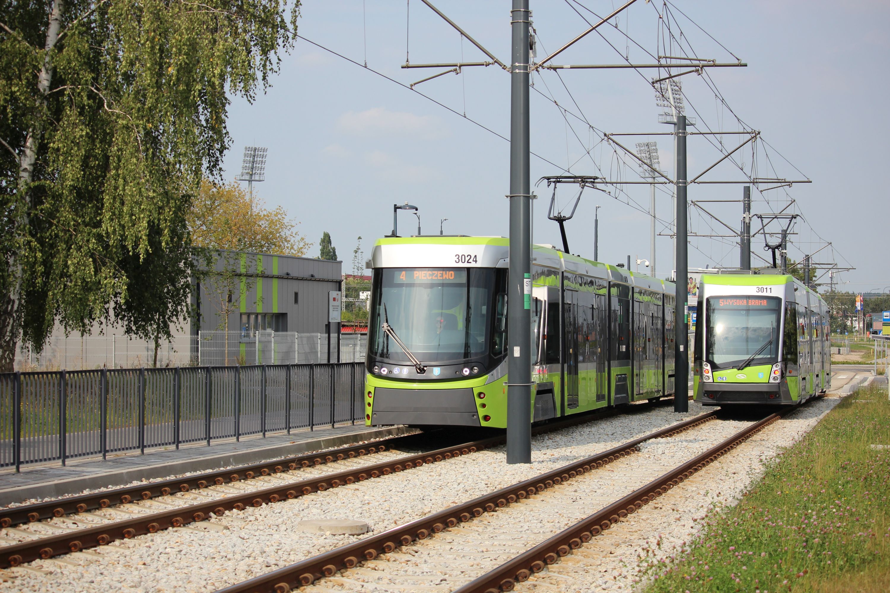 Durmazlar Panorama DRP5H05 #3024 na linii 4 w kierunku Pieczewa i Solaris Tramino S111O #3011 na linii 5 w kierunku Wysokiej Bramy mijają się w pobliżu przystanku Piłsudskiego (18 sierpnia 2024)