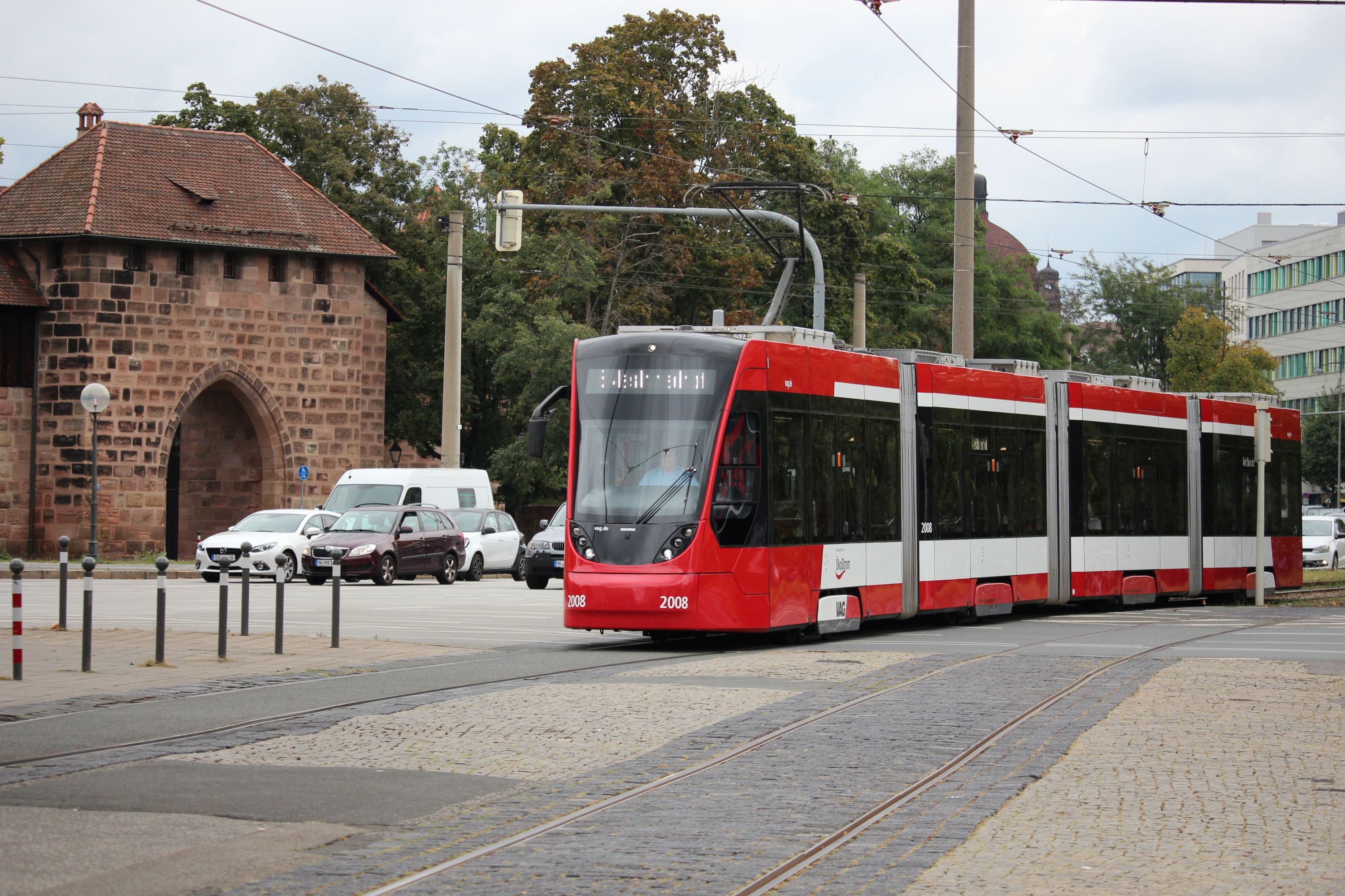 Siemens Avenio GTA8 #2008 na linii 6 zbliża się do przystanku Plärrer w Norymberdze, w tle Brama Szpitalników [Spittlertor] (13 września 2024)