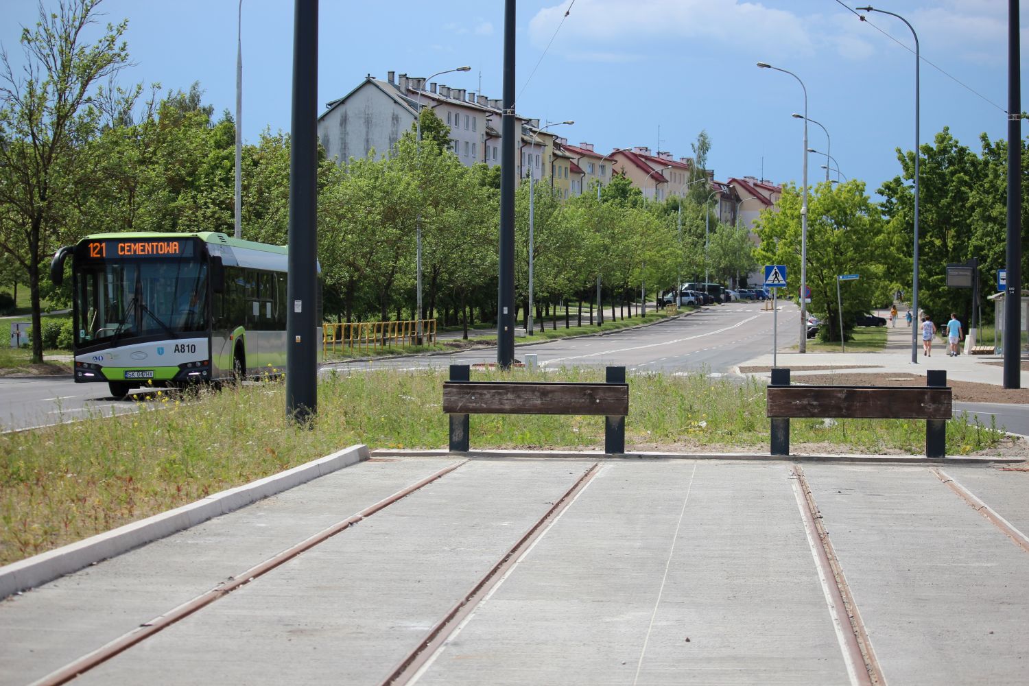 Kozły oporowe na końcu torowiska w ulicy Wilczyńskiego (widok w kierunku Jarot), obok przejeżdżający Solaris Urbino 12 IV #A810 na linii 121 (19 maja 2024)